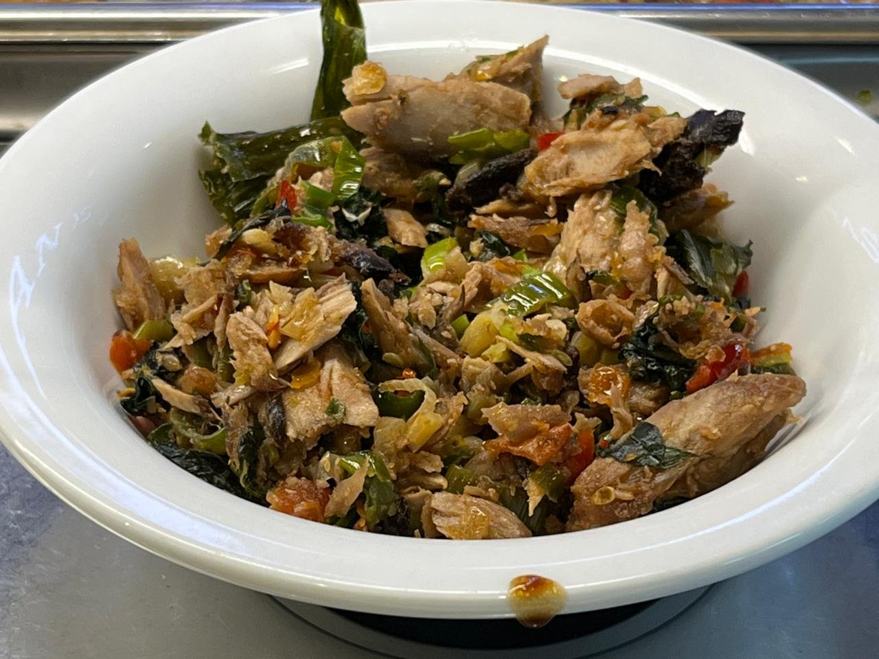 Ayam woku khas Manado dengan bumbu rempah dan daun kemangi